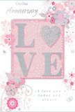 An anniversary card with a gentle, romantic spirit appears as if laid out on a windowsill overlooking Highgate's greenery, its design capturing the feeling of a soft, hand-tied bouquet. At the centre, the word LOVE is rendered in bold, raised lettering, each letter edged with a fine line of shimmering silver glitter that sparkles subtly when the light shifts. This central motif rests on a blush-pink rectangle, the colour reminiscent of the palest petals in a pastel rose arrangement, creating a warm, welcoming glow. Flowing outward from this heart of the design, stylised flowers and slender leaves wind sinuously across the card. The blooms are drawn in delicate strokes of blush, white, and muted grey, with light shading that gives them a faintly three-dimensional presence, like pencilled florals brought gently to life. These floral elements curl and loop around the word LOVE, forming an airy frame that leaves generous pockets of negative space, preventing the design from ever feeling crowded. Subtle touches of silver foil or ink accent some petals and stems, giving an understated glint, much like sunlight flickering through the trees of nearby Waterlow Park. Within this floral surround, an elegant cursive message offers anniversary wishes and a promise of ongoing devotion, its lines balanced and easy to follow. The lighting is soft and diffuse, making every glittered highlight and fine outline clearly visible while maintaining a tranquil, intimate atmosphere. The overall composition feels like a bouquet of emotions translated into paper-refined, tender, and perfectly suited for marking another year of shared life in the calm, leafy setting of Highgate.